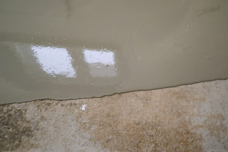 Applying epoxy resin on a concrete surface, creating a smooth and durable finish ideal for industrial and commercial settings