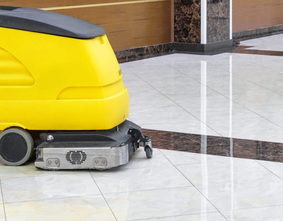 Cleaning machine in an office lobby. Cleaned floor in the interior of company or luxury hotel. Yellow vacuum equipment for cleaning on a shiny marble floor. Concept of professional cleaning service.