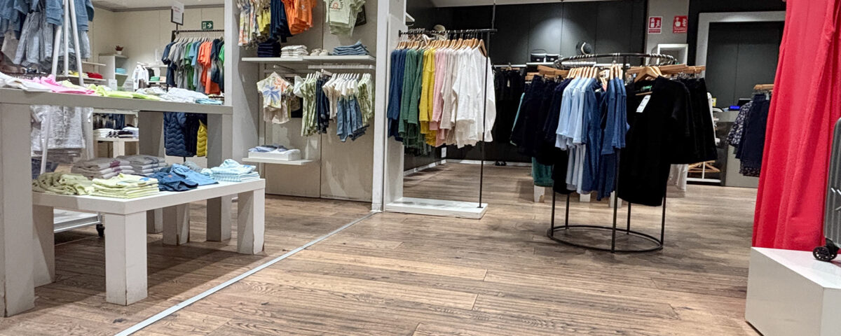 Alicante, Spain - May 20, 2025: Fashion retail store interior showcasing colorful clothing displays, wooden flooring, and modern lighting, creating a vibrant shopping atmosphere
