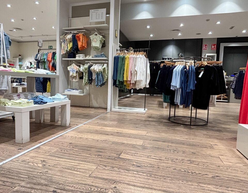 Alicante, Spain - May 20, 2025: Fashion retail store interior showcasing colorful clothing displays, wooden flooring, and modern lighting, creating a vibrant shopping atmosphere