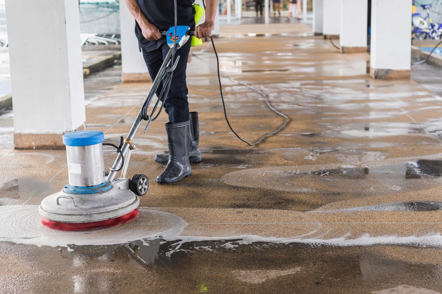 How-Dirty-Floors-Are-Costing-Your-Business-More-Than-You-Think Worker cleaning sand wash exterior walkway using polishing machine and chemical or acid