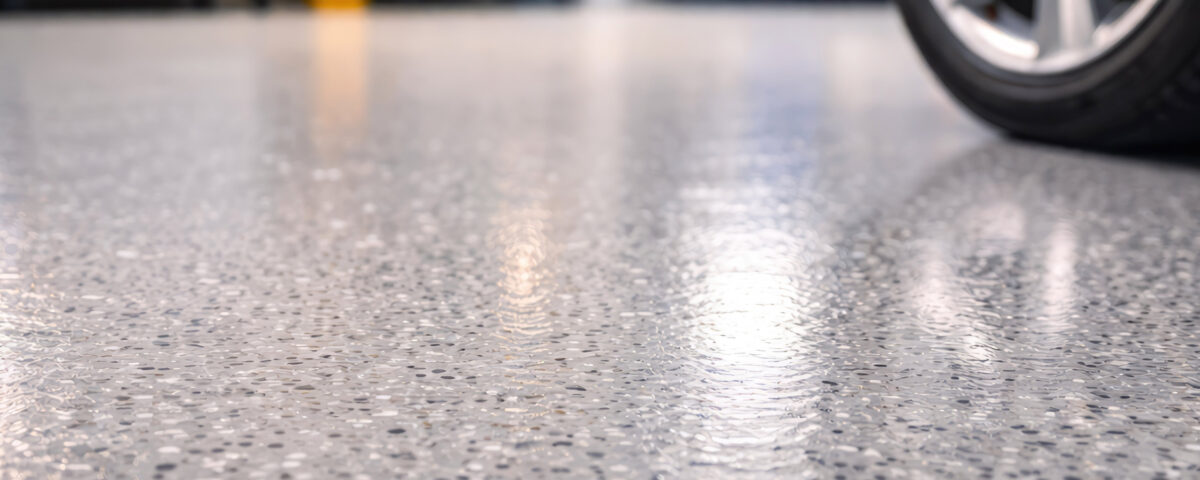Close up of polished epoxy garage floor with car wheel