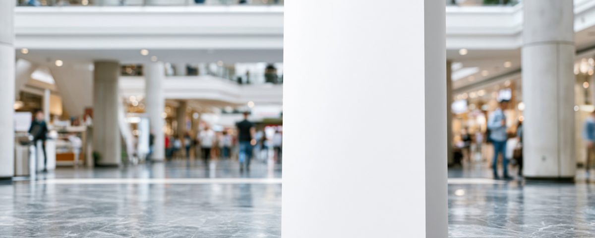 Blank advertising display standing in busy shopping mall