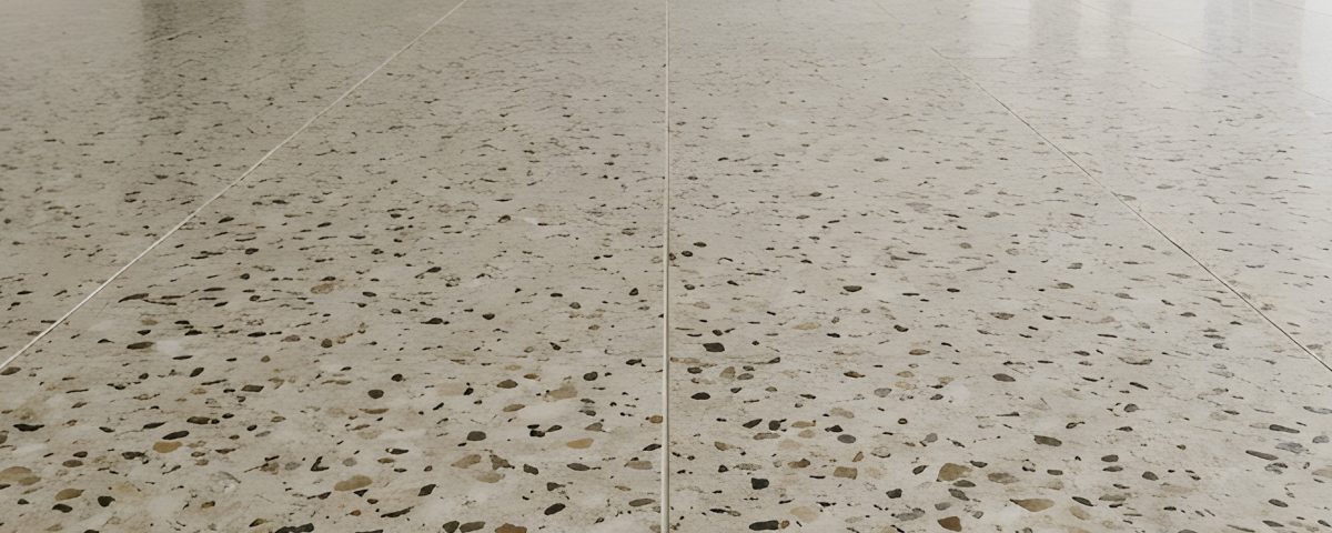 Terrazzo flooring inside a large modern empty commercial office building with white walls and windows.